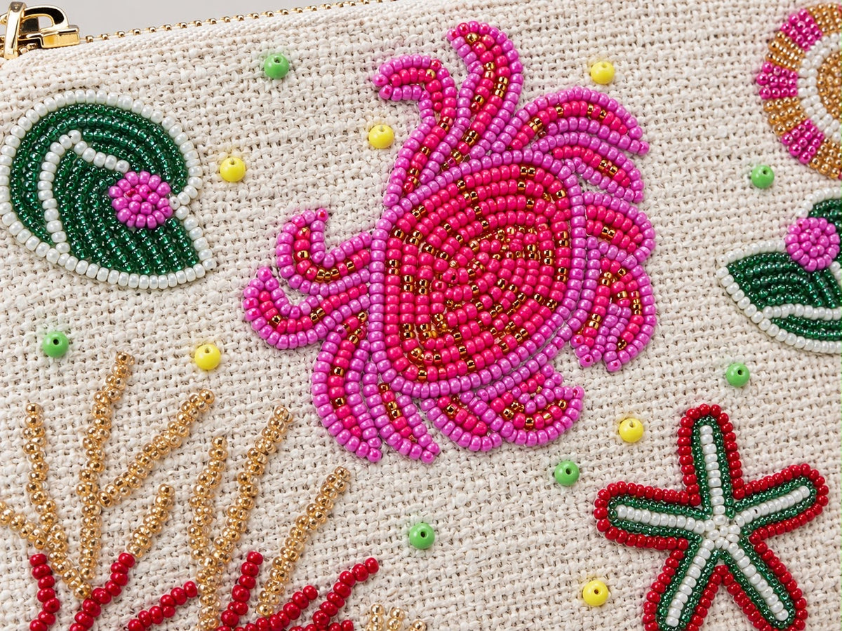 Close up of the hand beaded pink crab, red and green starfish and gold coral on the clutch