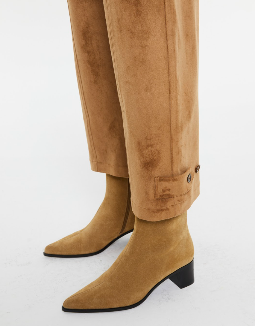 Detail of Andam camel suede-effect trousers with button-tab ankle cuff styled with camel suede ankle boots