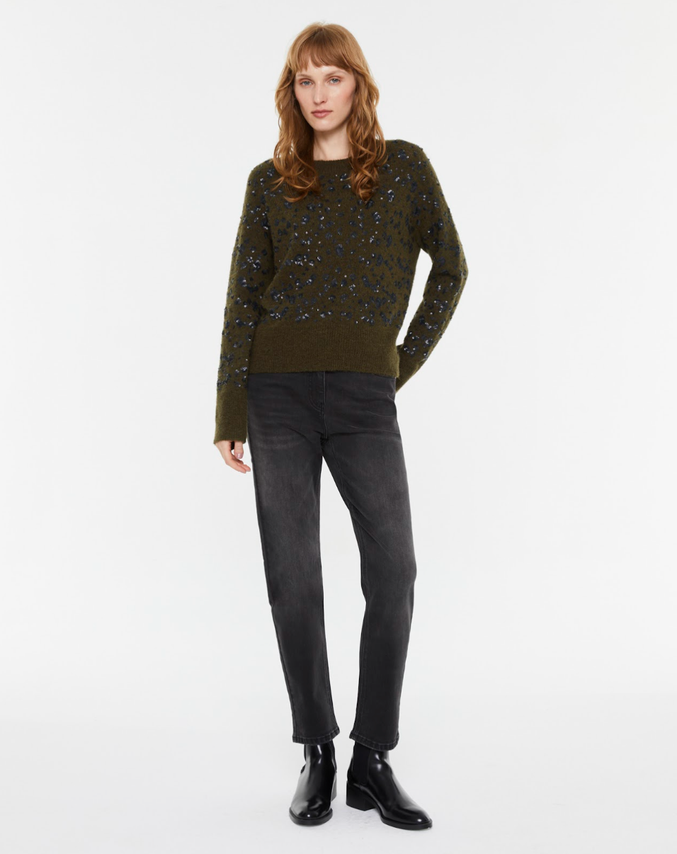 Model wearing the Andam sequin knit jumper in khaki with black sequins styled with charcoal denim jeans and black ankle boots.
