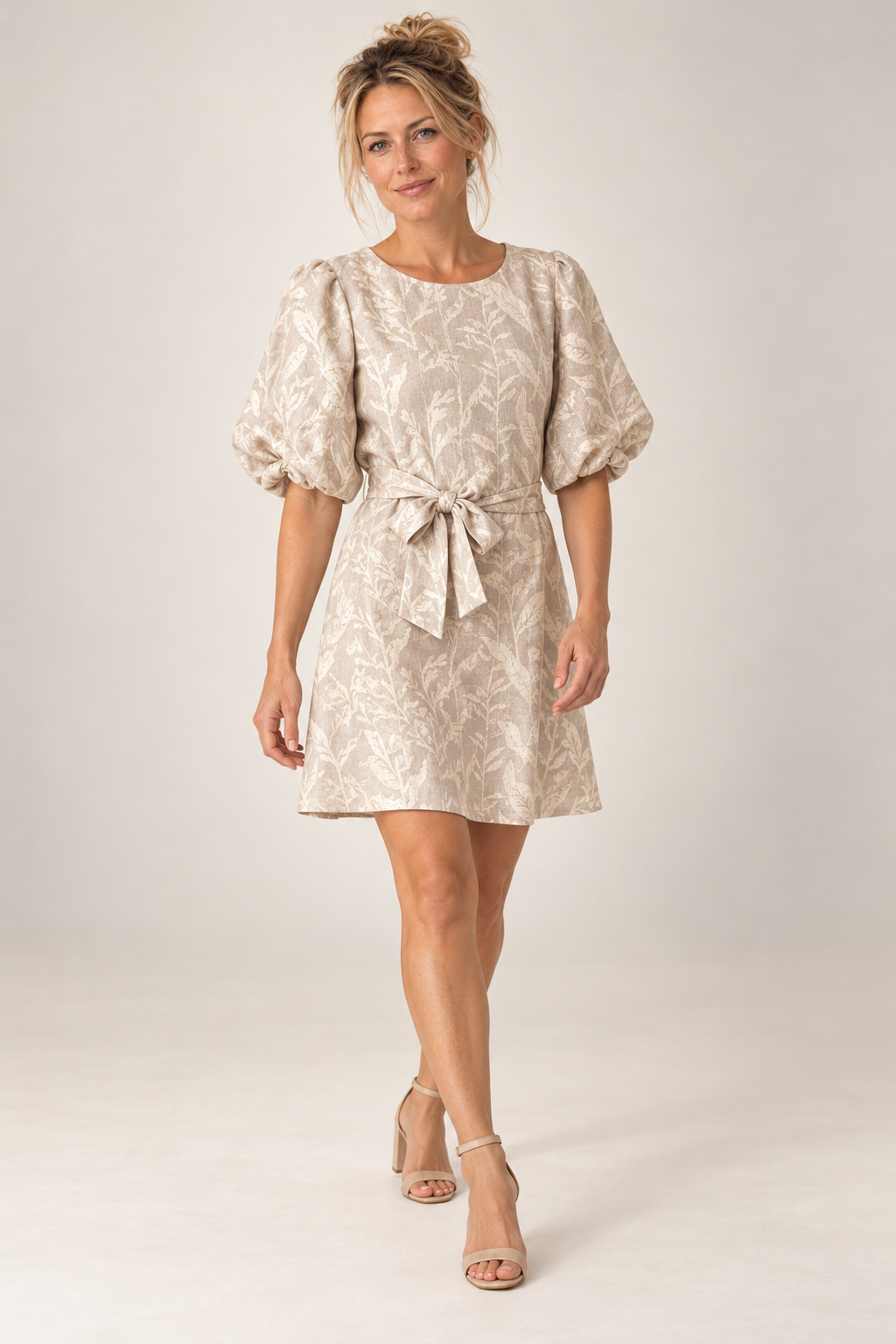 Model walking in the Smashed Lemon dark sand and gold leaf print dress