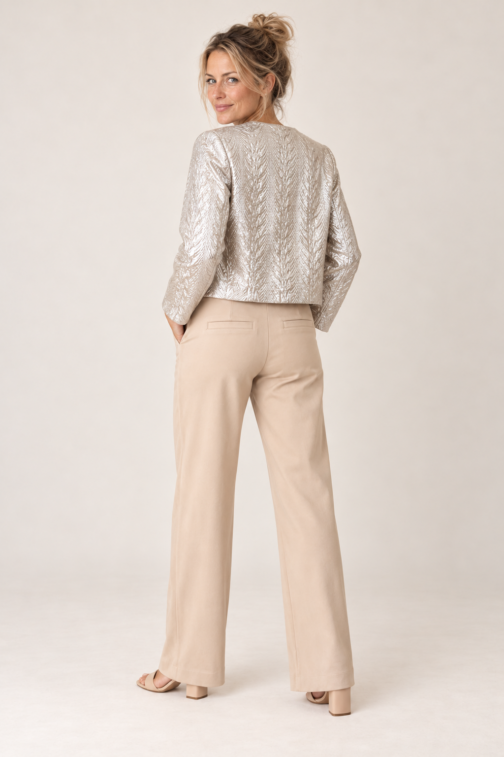 Back view of the sand wide leg pants worn with the Smashed Lemon silver jacket