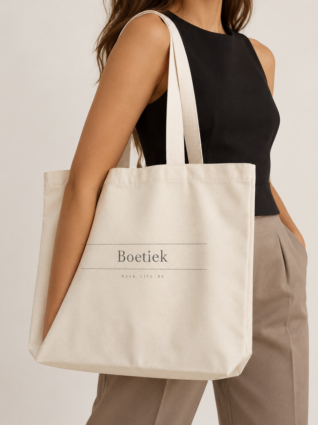 Model carrying the Boetiek medium cream canvas tote on her shoulder
