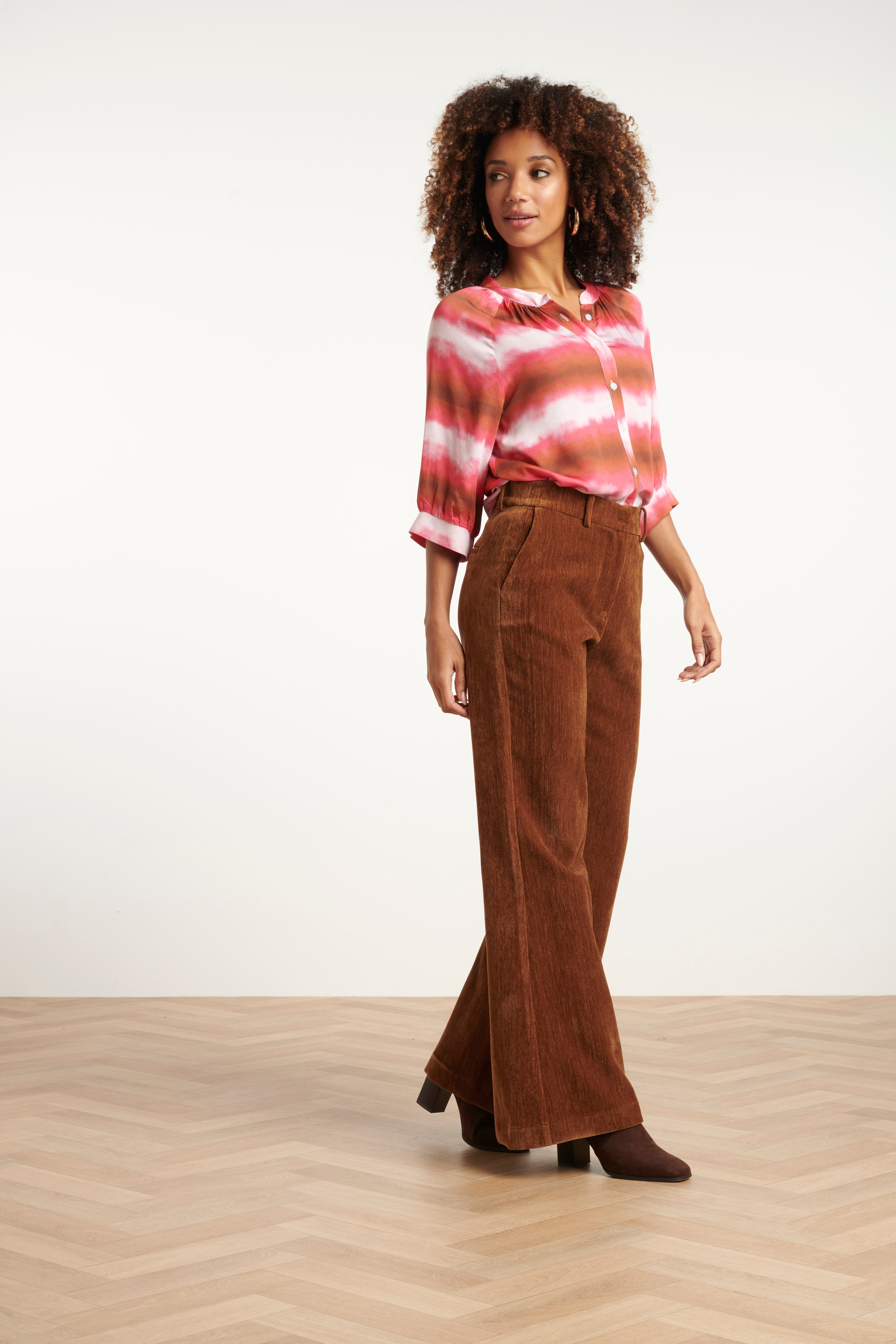 Smashed Lemon flared velvet pants in rich brown, high-waisted with wide flared leg, three-quarter angle view