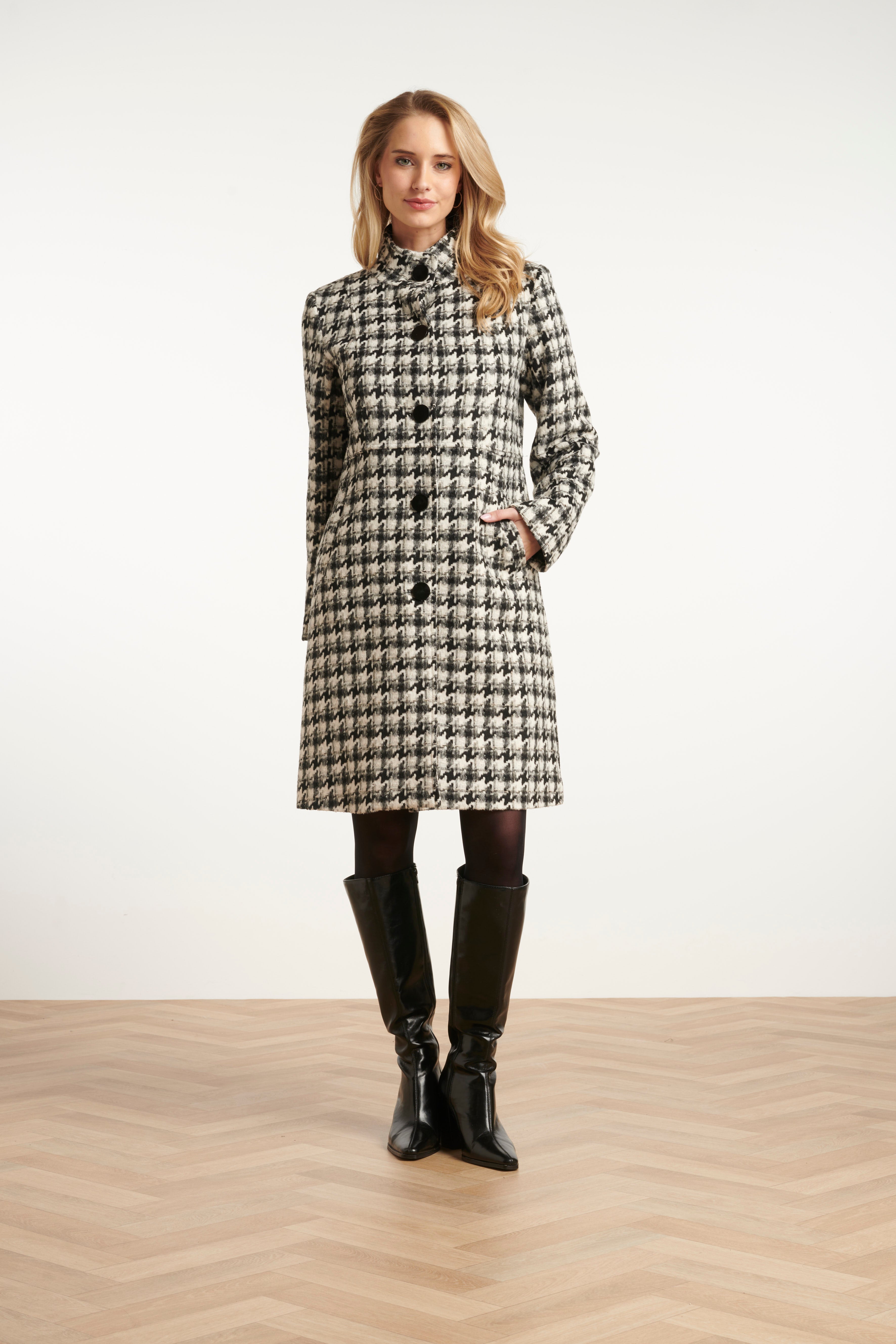 Smashed Lemon houndstooth coat in black and off-white, knee-length with spread collar, front view with hands in pockets