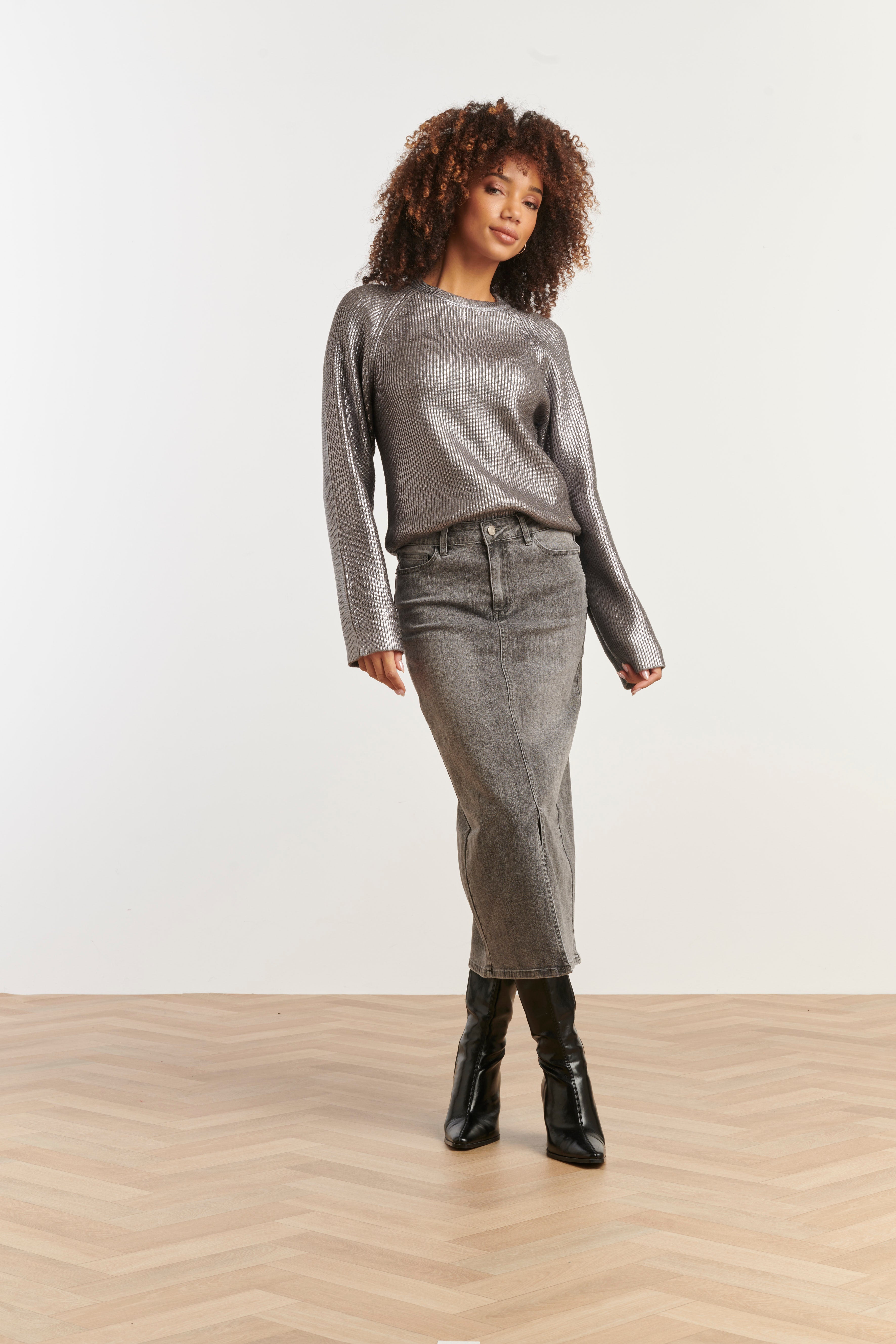 Smashed Lemon ribbed knit top in silver with metallic shimmer, long sleeves and relaxed fit, front angled view with hand on hip