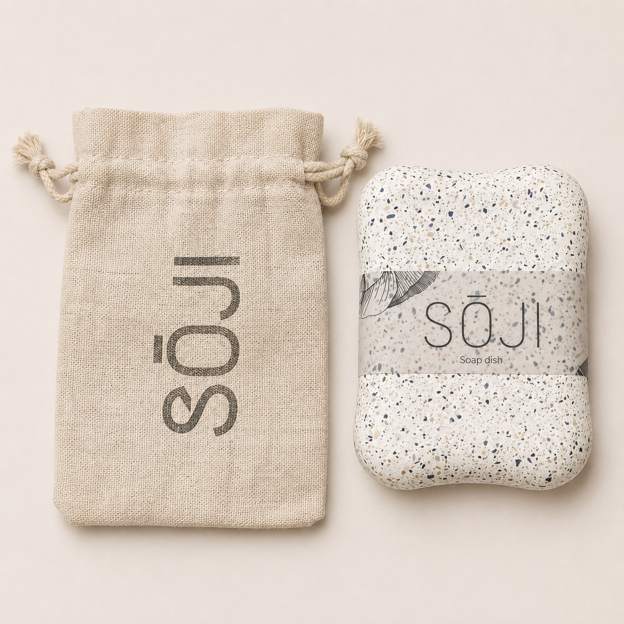 SŌJI terrazzo soap dish with rounded edges presented alongside a natural cotton drawstring pouch.