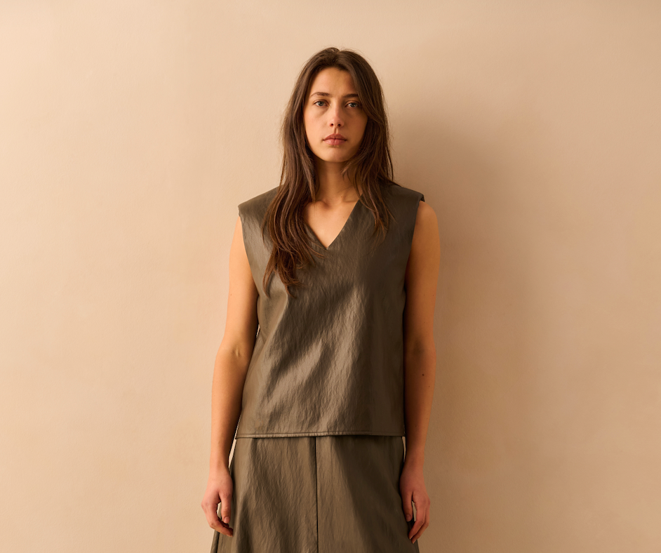 Front view of the YAYA Faux Leather Spencer Top with Shoulder Pads in Dark Taupe Grey featuring a sleeveless faux leather finish, structured shoulder pads and a flattering V-neckline.