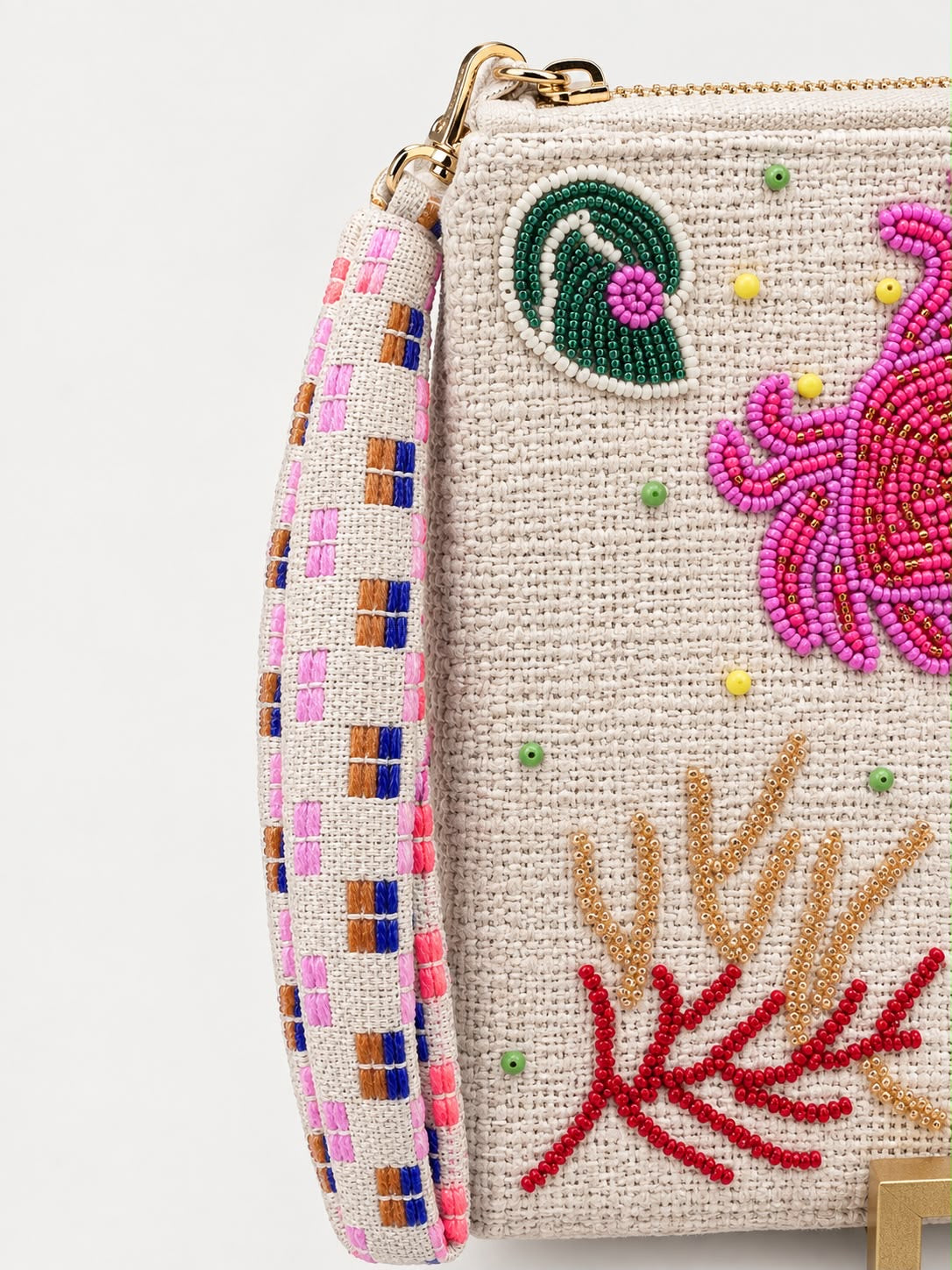 Detail of the gold tone zip and detachable woven strap in pink, lilac, tan and cobalt check