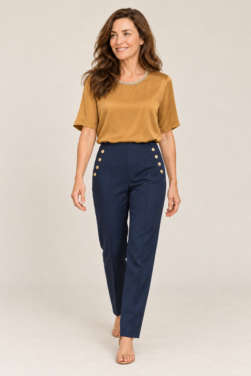 Model walking in the Andam navy tapered pants worn with the camel satin blouse