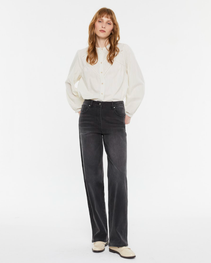 Model wearing Andam ecru textured blouse styled with grey jean