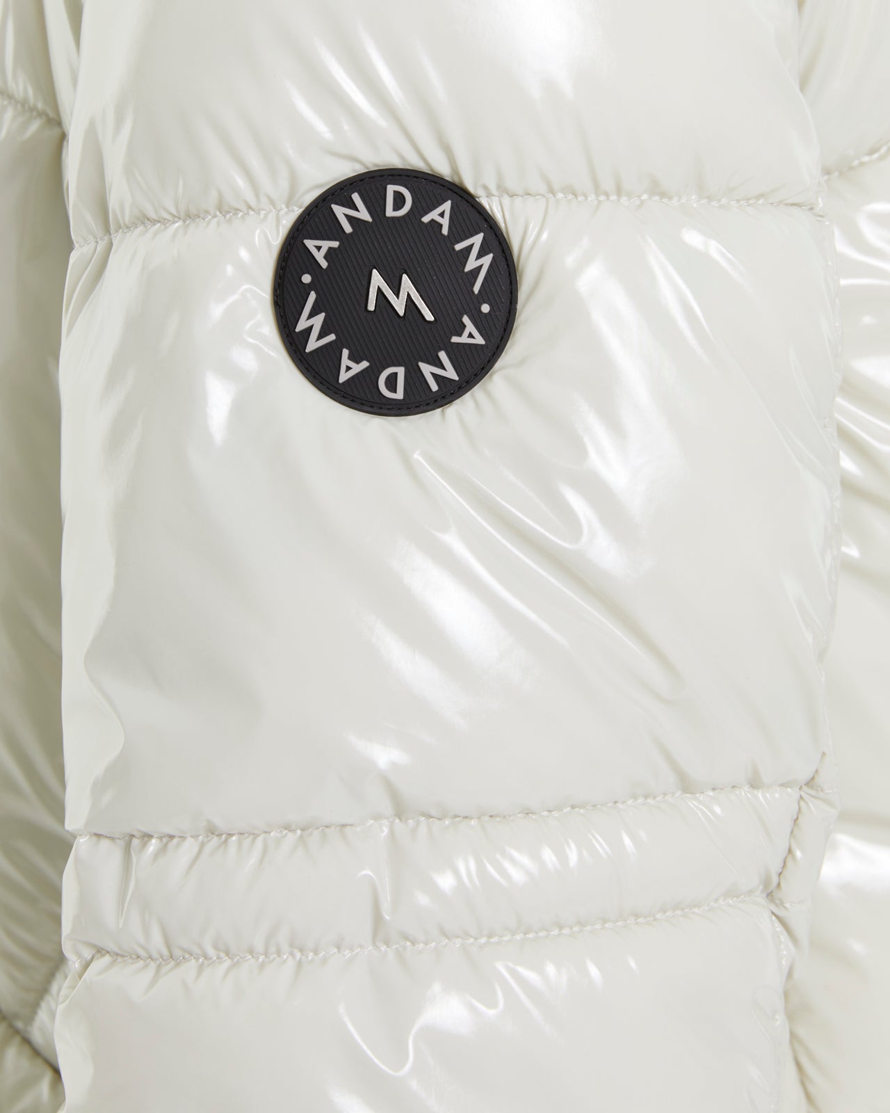 Andam logo patch detail on ecru puffer jacket sleeve