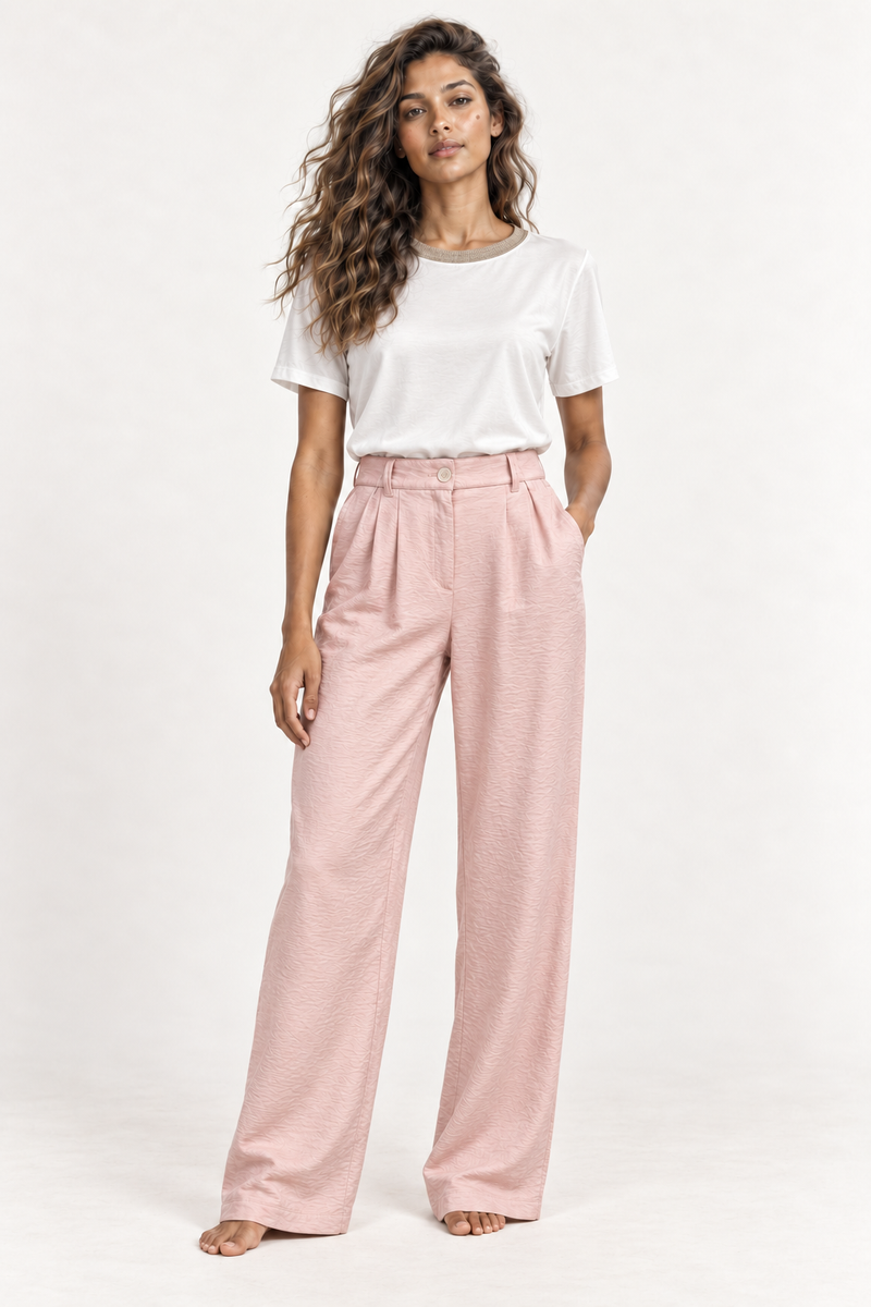Model standing in the Andam pink crinkled viscose flared leg pants worn with the crudo blouse