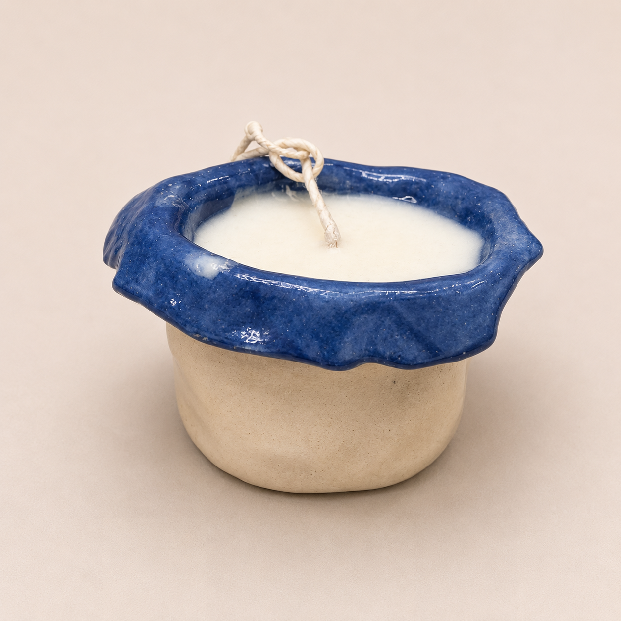 Boetiek Atelier x Fragile Bergamot and Sandalwood small candle in a handcrafted ceramic vessel with blue glazed rim.