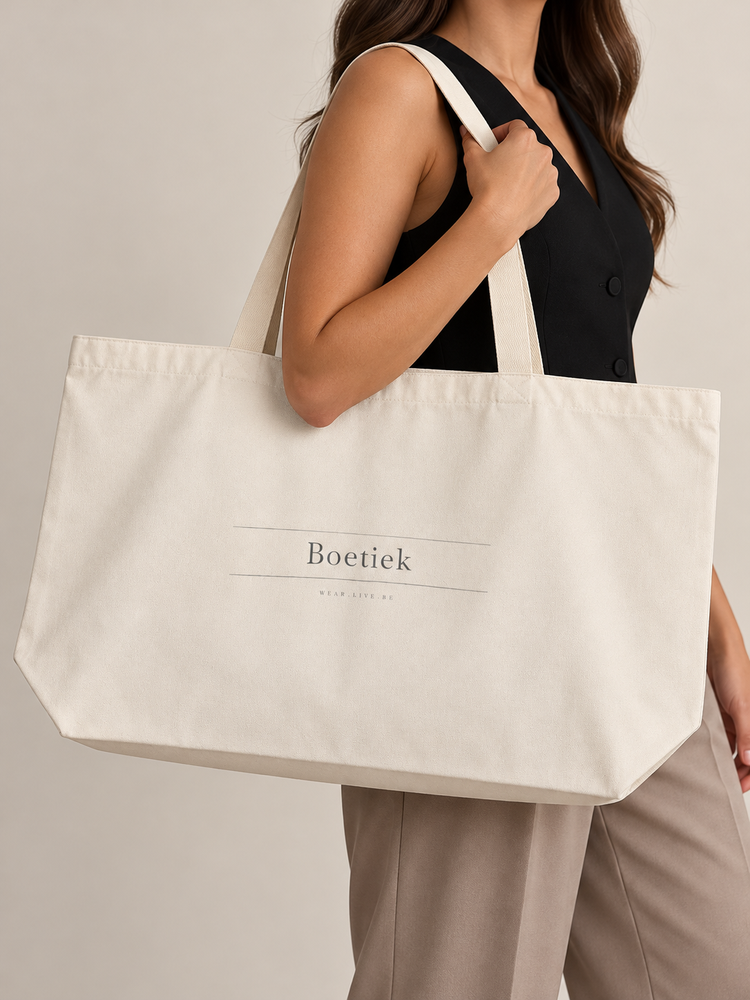 Model carrying the Boetiek large cream canvas tote over her shoulder