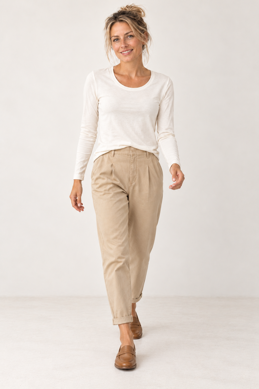 Model walking in the YAYA off white long sleeve T-shirt and sand beige loose fit trousers