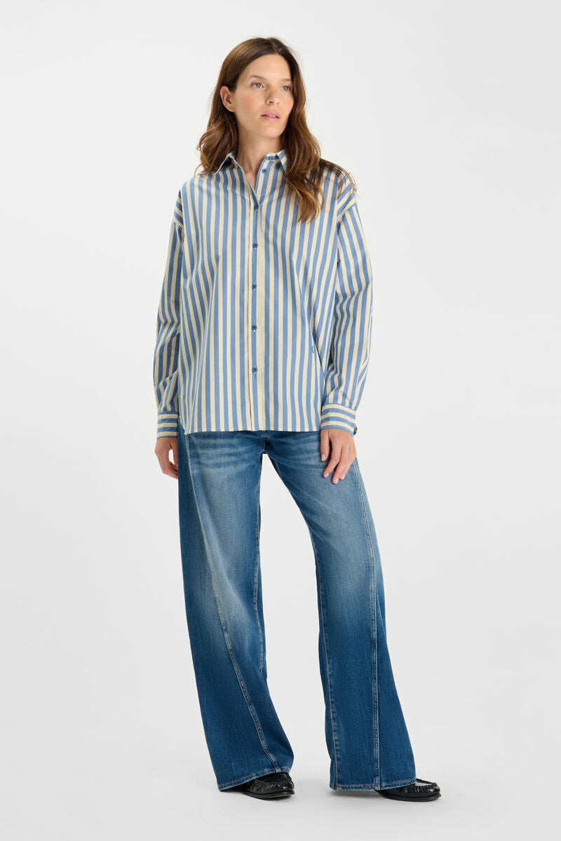 Model wearing Le Temps des Cerises sky blue stripe button-through shirt with a relaxed fit, classic collar and long sleeves.