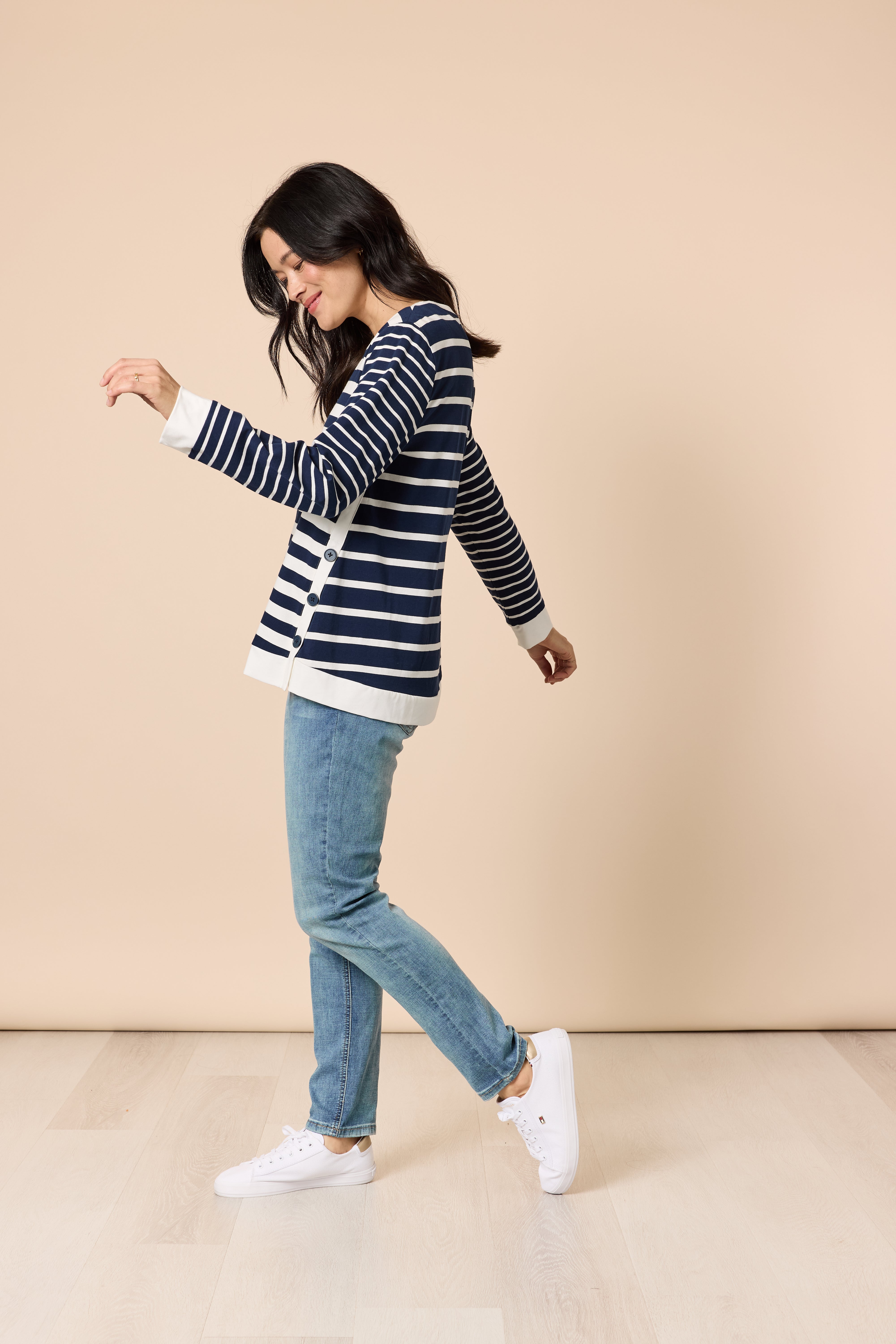 Model side view wearing navy ivory striped top