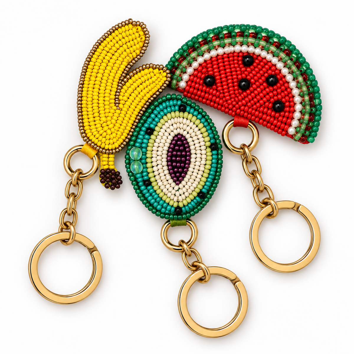 Three Piti Cuiti hand beaded fruit bag charms, banana, watermelon and kiwi, on gold tone rings