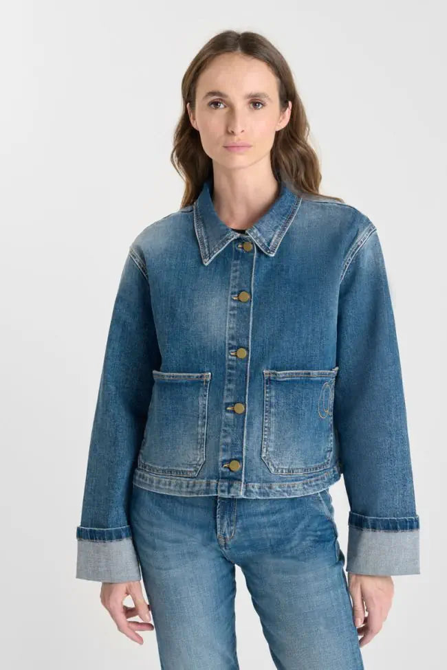 Model wearing the Le Temps des Cerises Aleska cropped blue denim jacket with matching jeans.