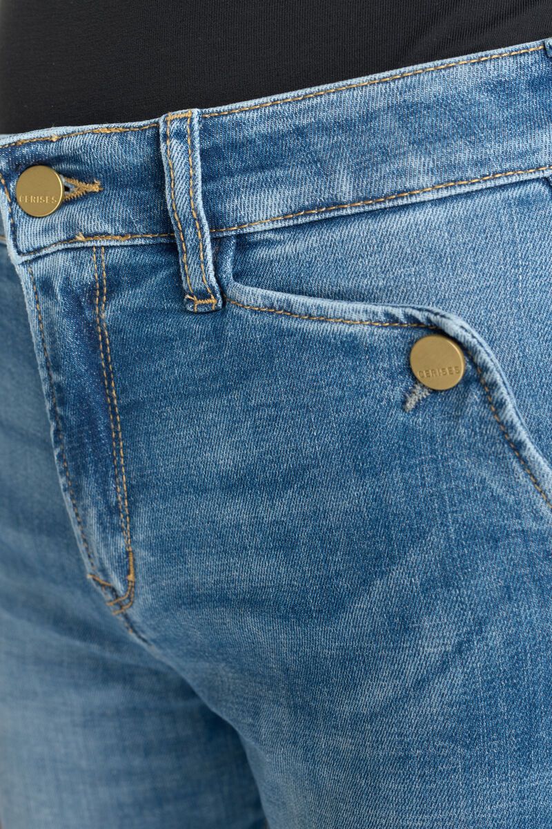 Close-up of front pocket and branded button detail on Le Temps des Cerises blue jeans
