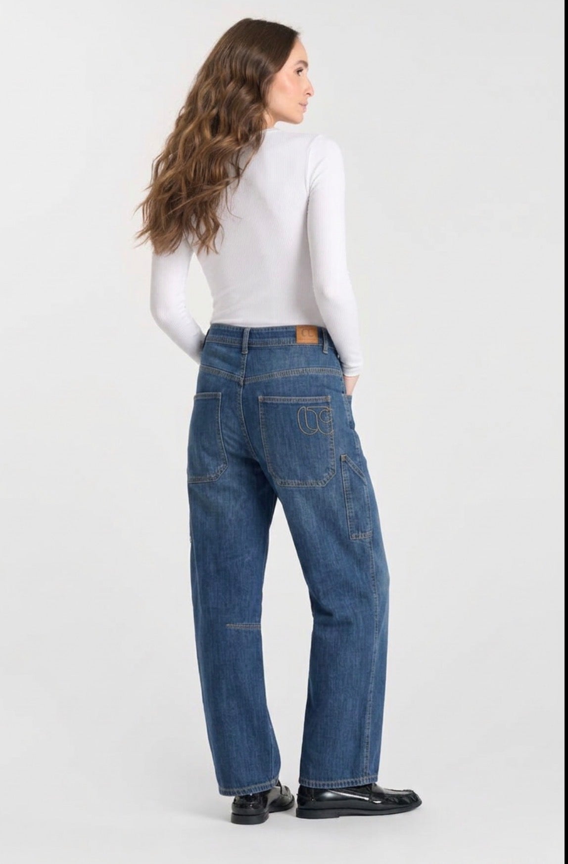 Model wearing Le Temps des Cerises Madie denim jeans in Dark Blue, showcasing the relaxed straight-leg silhouette, utility pockets and back view
