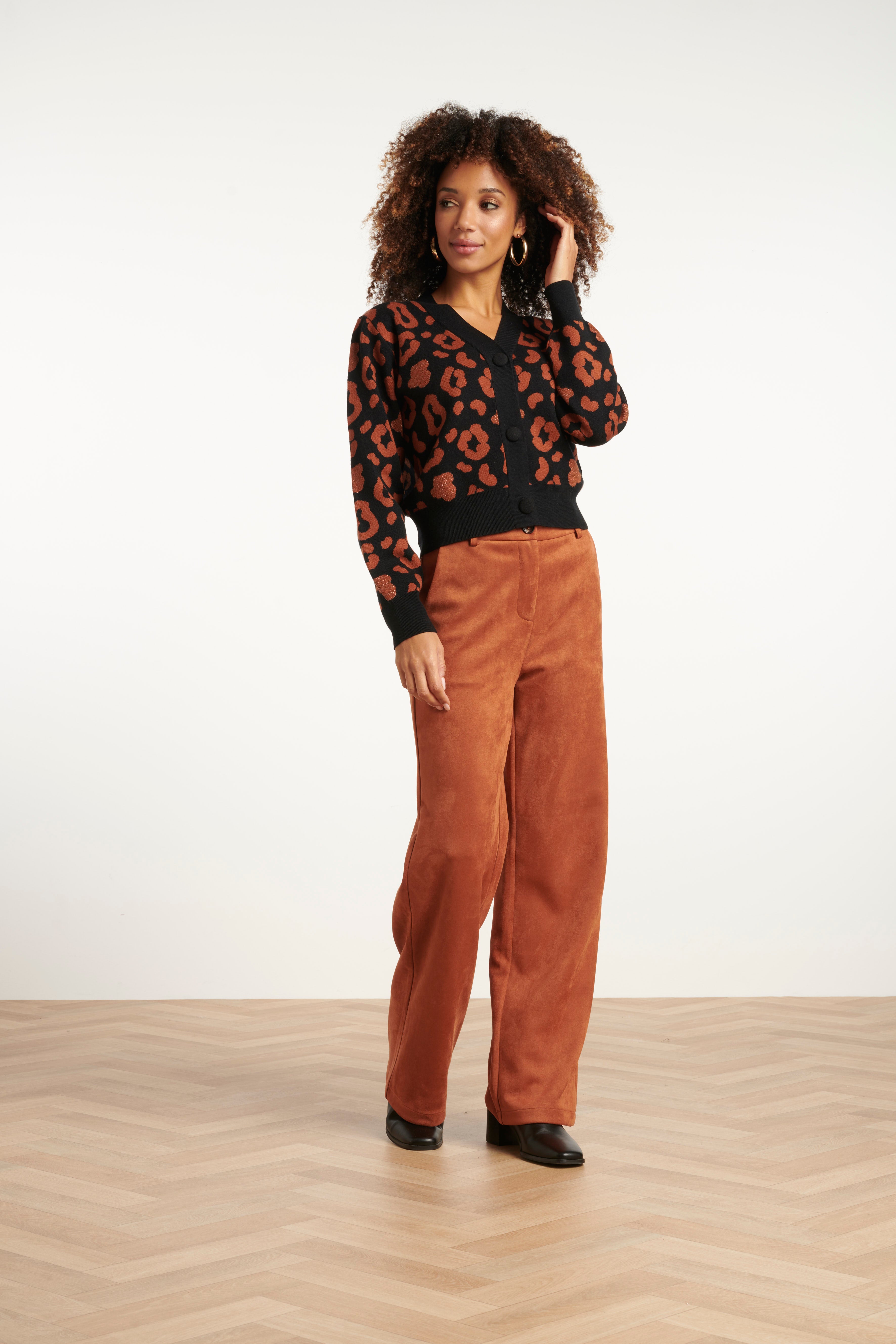 Smashed Lemon button-up knit cardigan in black with cognac leopard print, long sleeves, front view with hand at neckline