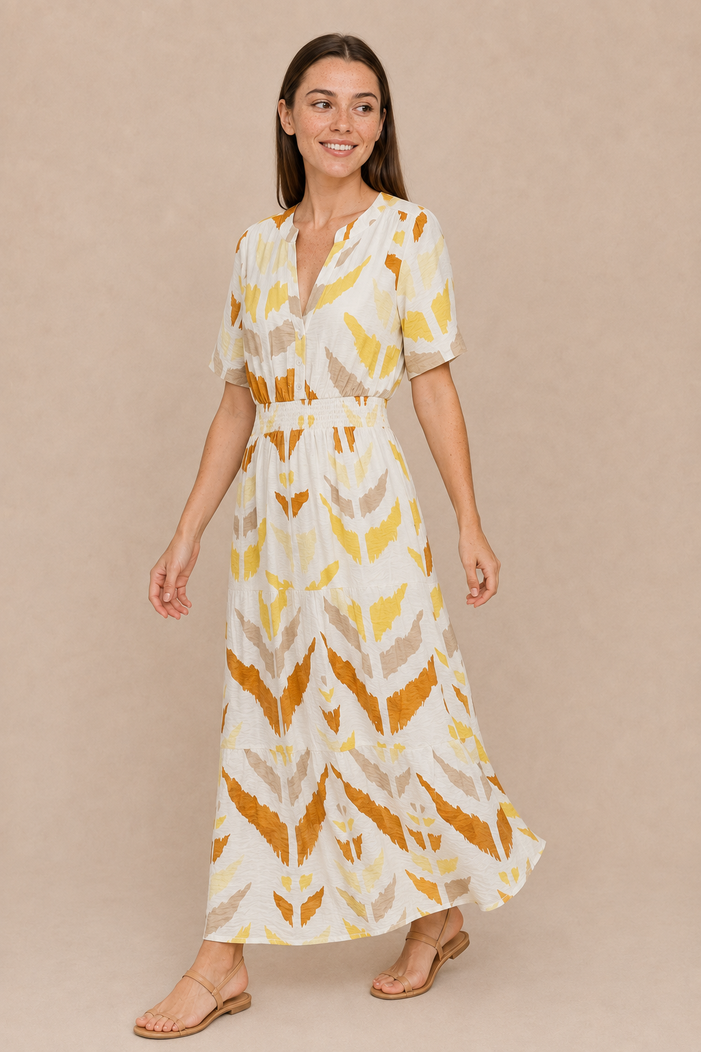 Woman wearing the Smashed Lemon printed maxi dress in white and yellow, styled with tan sandals.