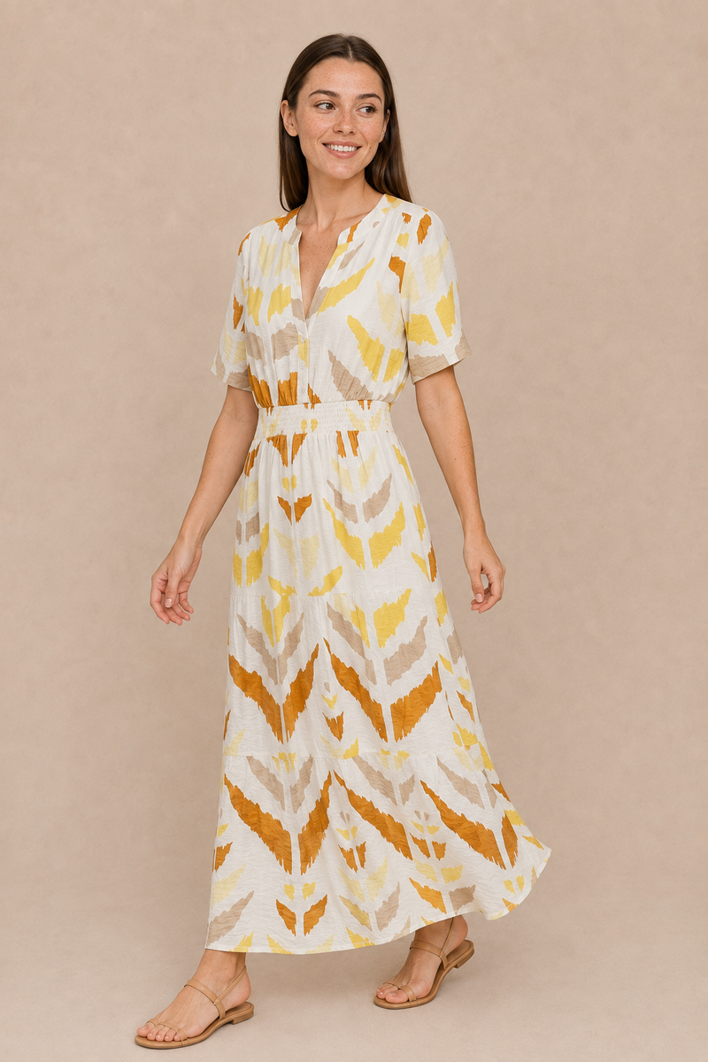 Woman wearing the Smashed Lemon printed maxi dress in white and yellow, styled with tan sandals.