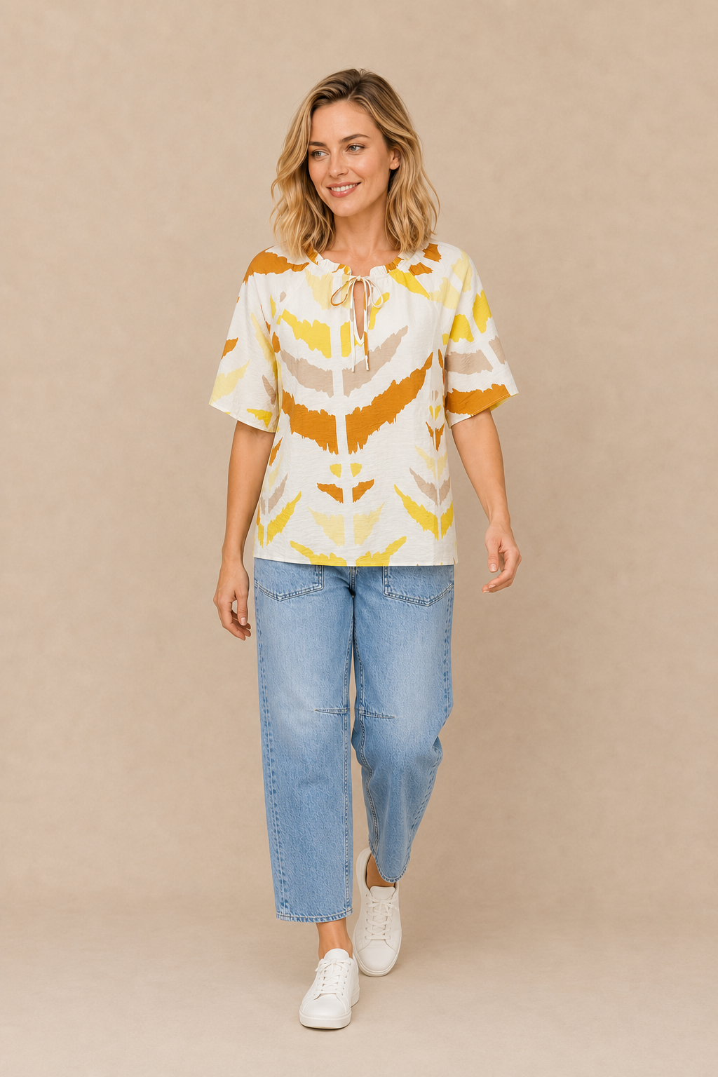 Smashed Lemon printed tie-neck top in white and yellow styled with blue jeans and white sneakers