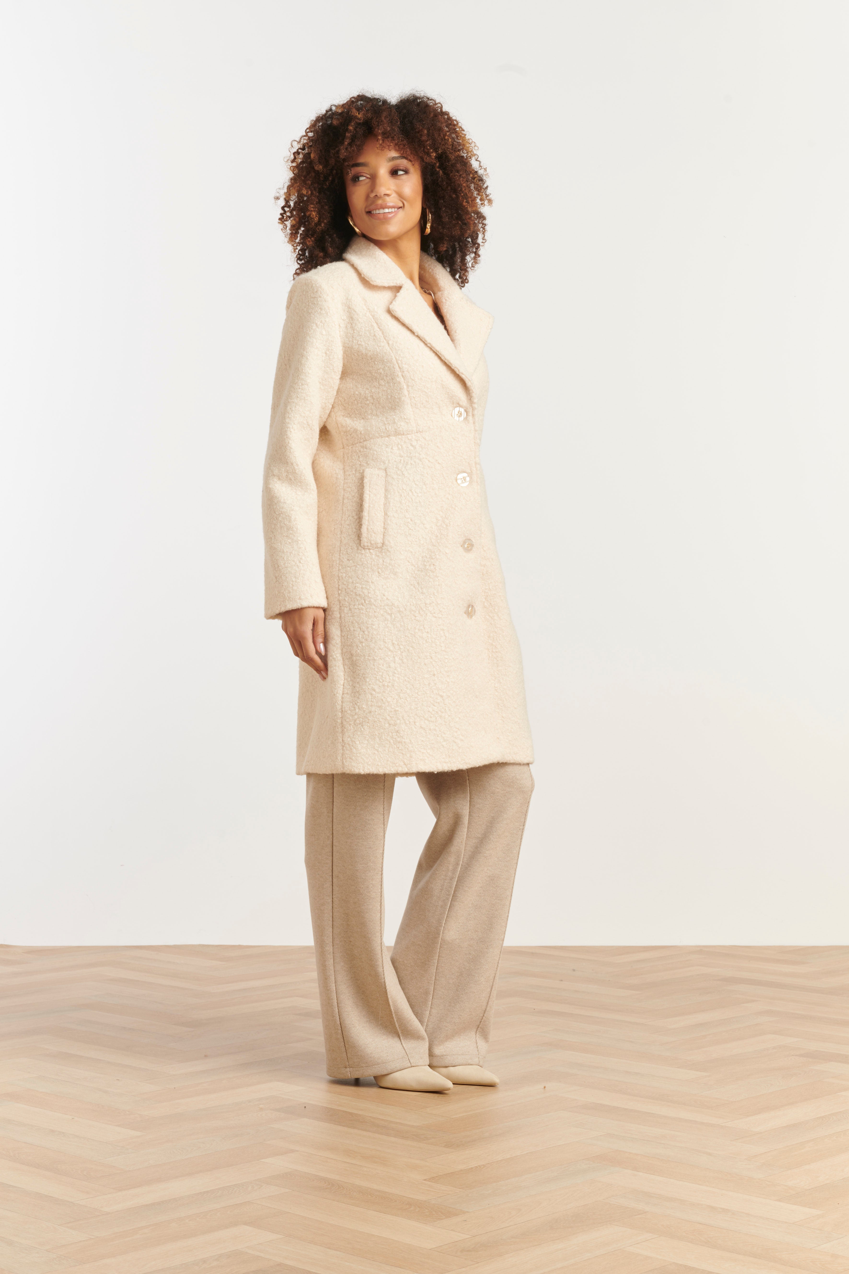 Smashed Lemon textured coat in off-white boucle, knee-length with notched lapels and button front, three-quarter angle view