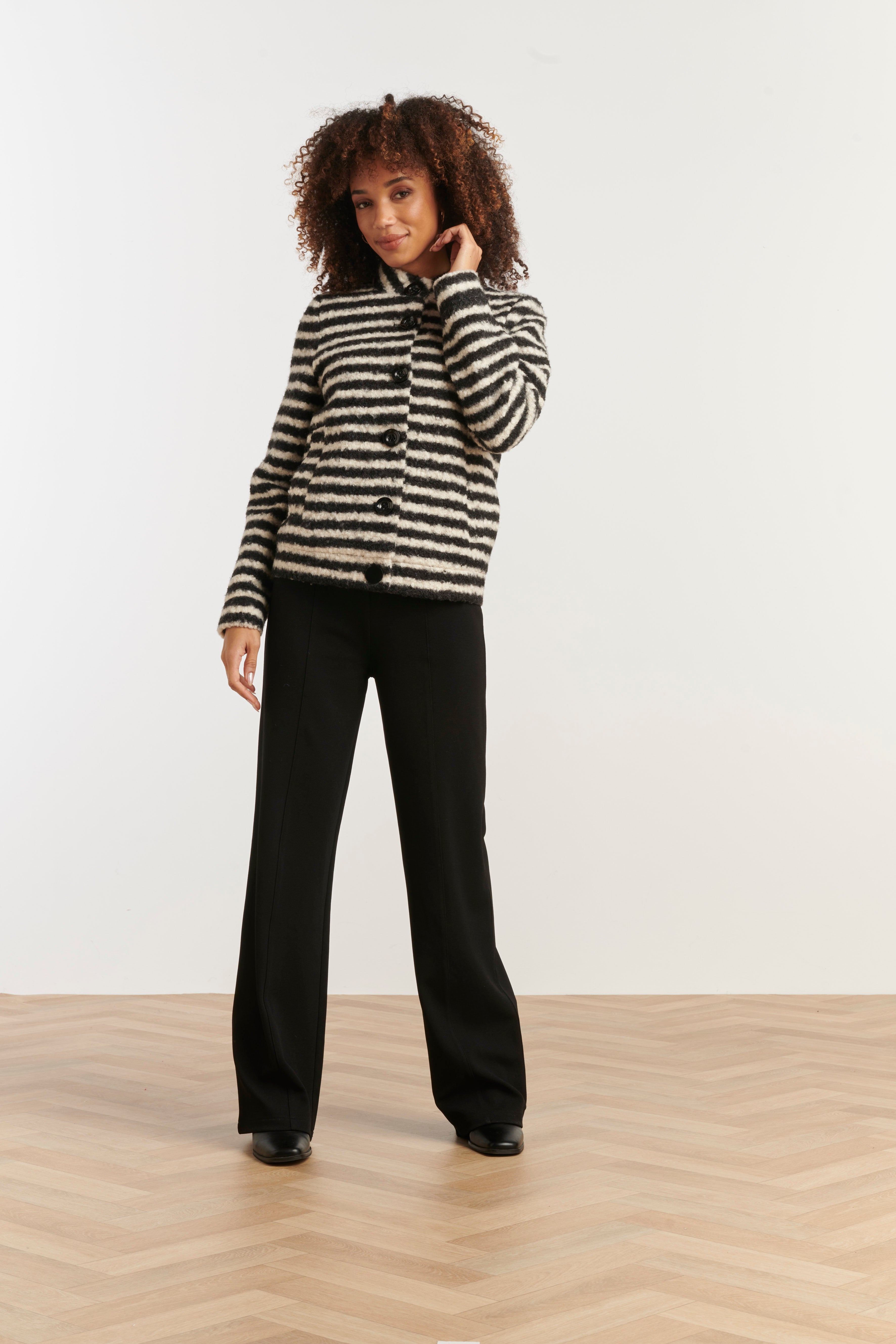 Smashed Lemon textured stripe coat in black and off-white, cropped boucle jacket with spread collar, front view with hand at face