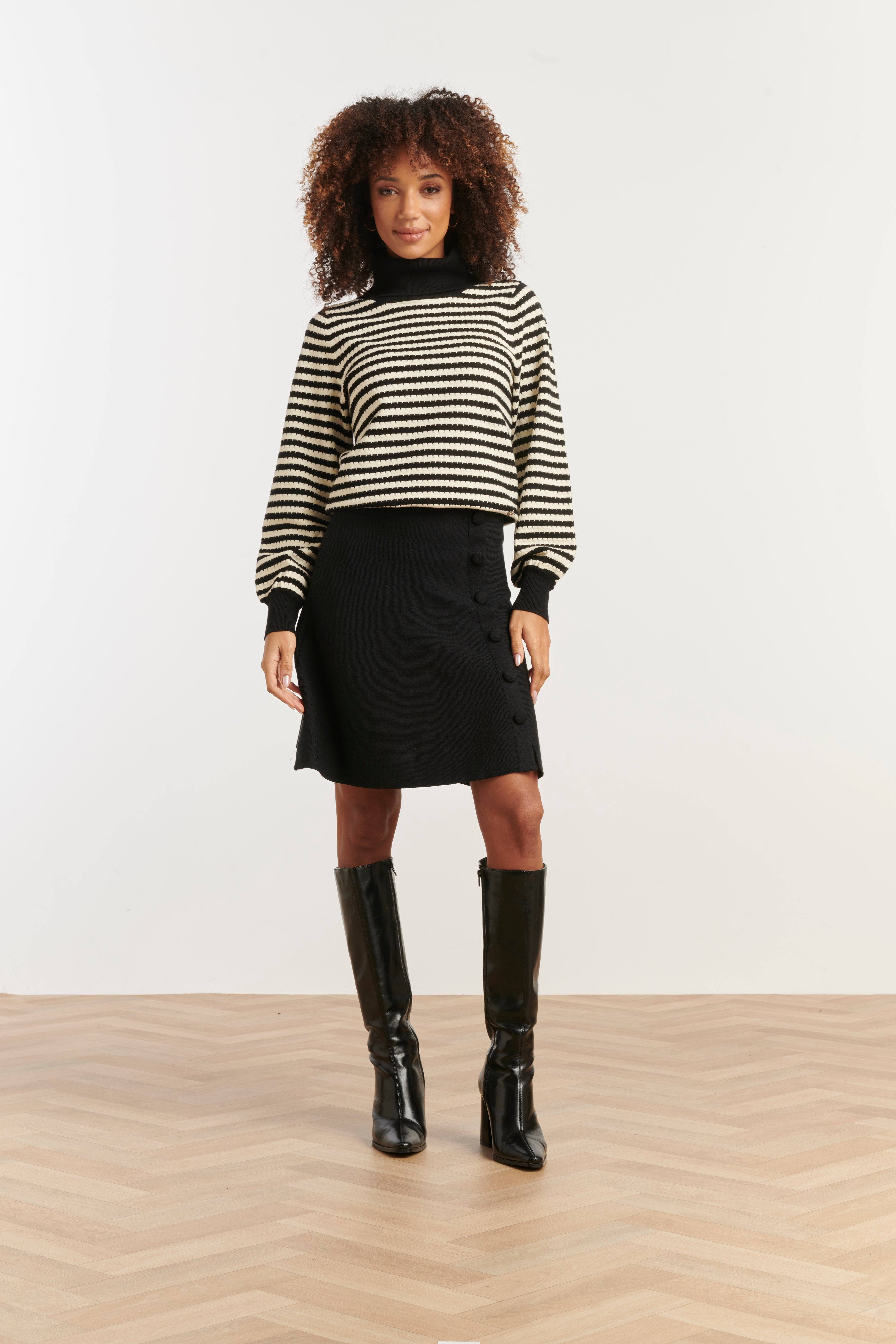 Smashed Lemon turtleneck knit top in black and off-white stripe, cropped fitted silhouette with long sleeves, front view