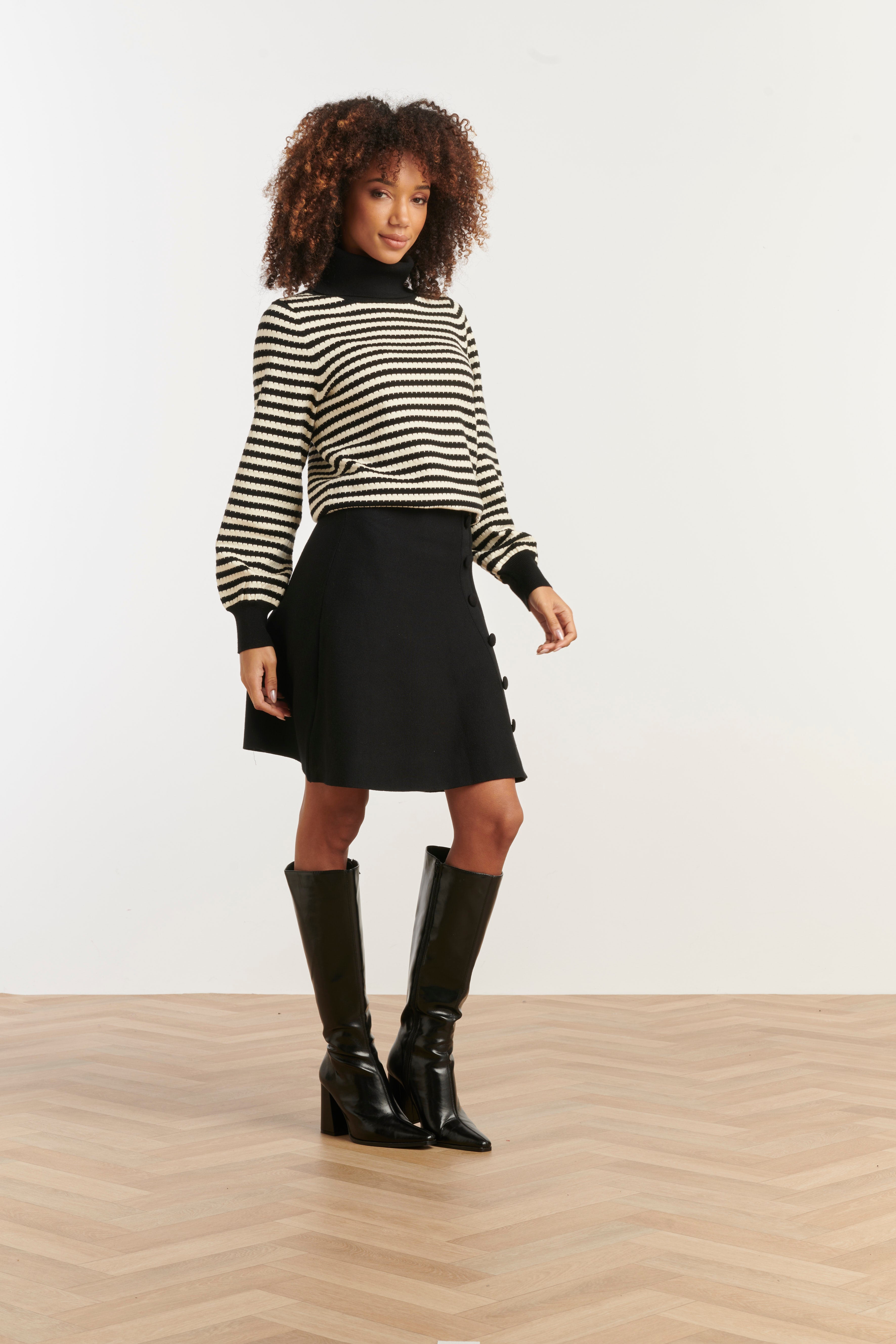 Smashed Lemon turtleneck knit top in black and off-white stripe, cropped fitted silhouette, three-quarter angle view