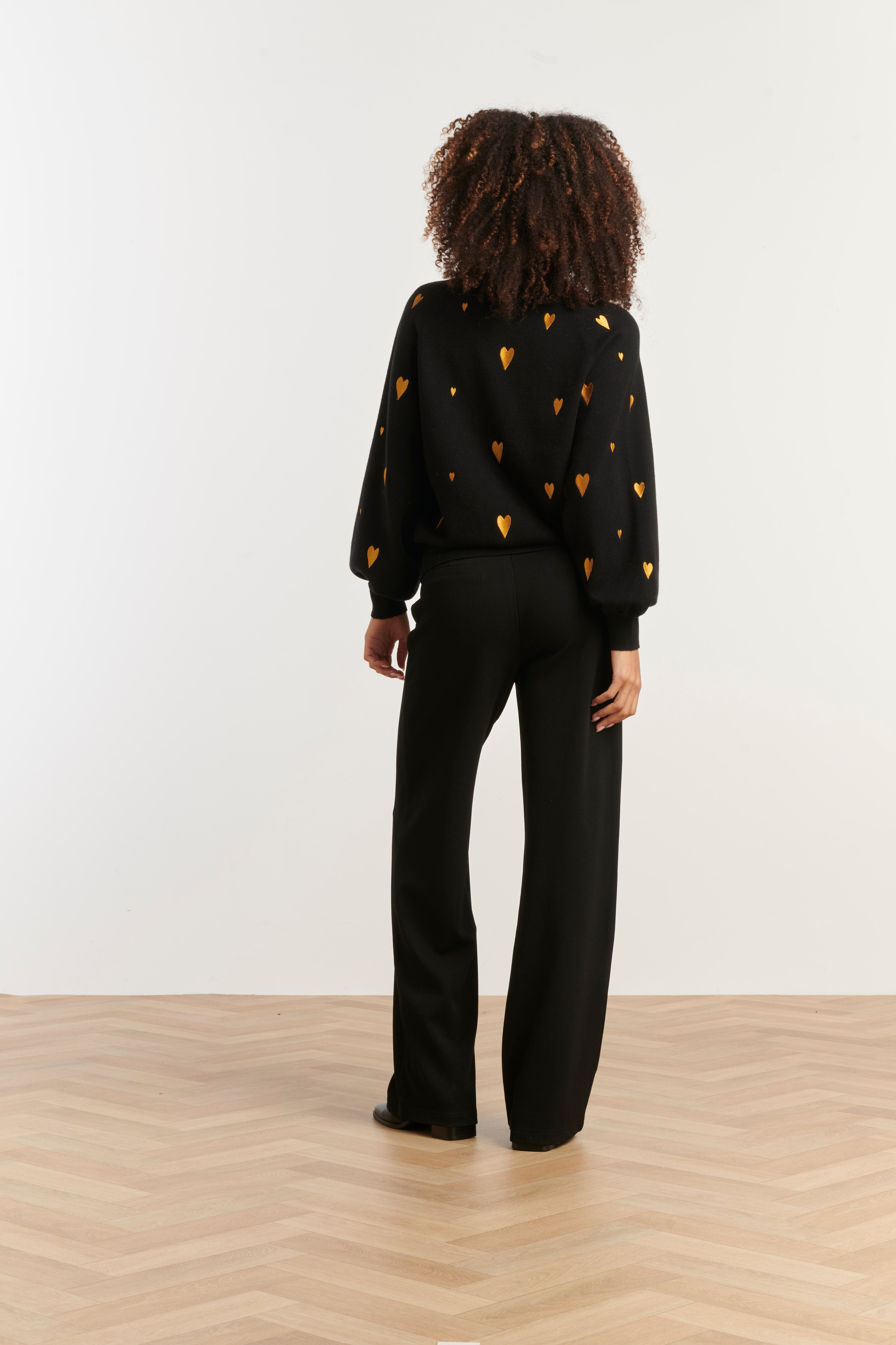 Smashed Lemon V-neck knit top in black with scattered gold heart print, long sleeves, back view