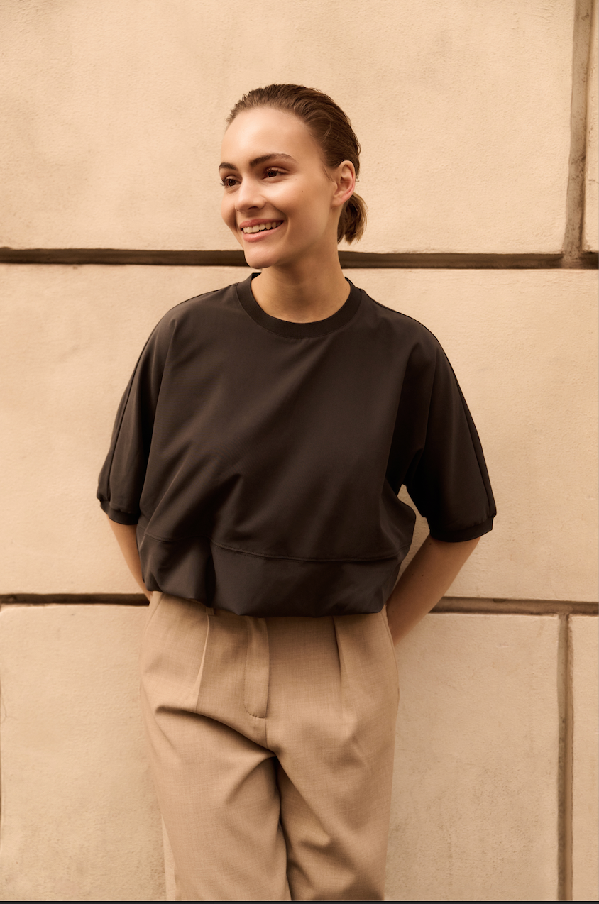 Model wearing YAYA short sleeve balloon hem top in oyster black styled with tailored trousers