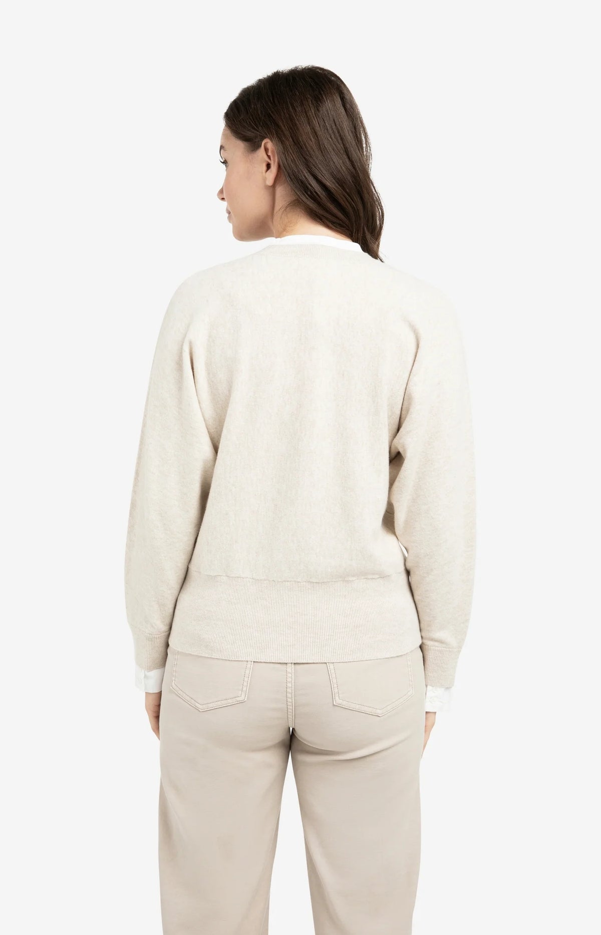 Back view of model wearing YAYA light beige sweater with inserted blouse detail