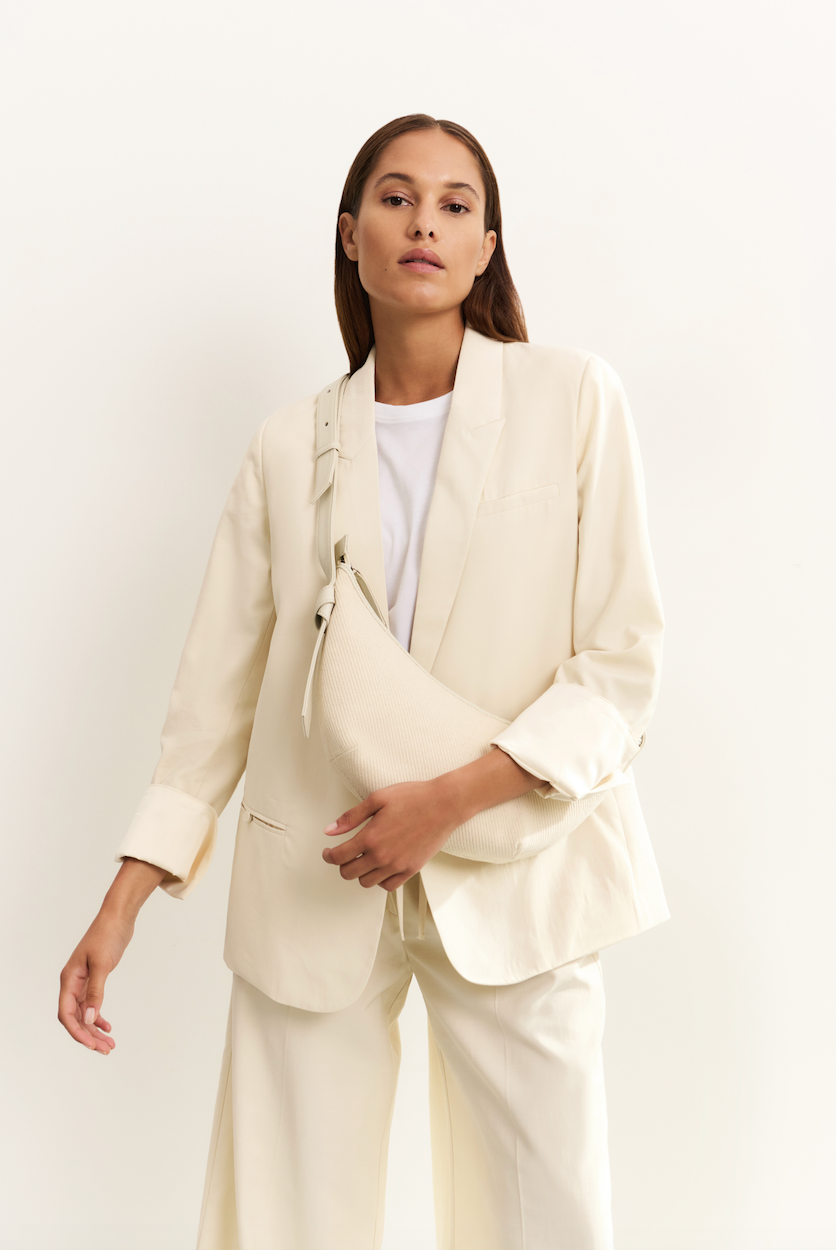 Model wearing YAYA wide leg trousers in off white front view with bag